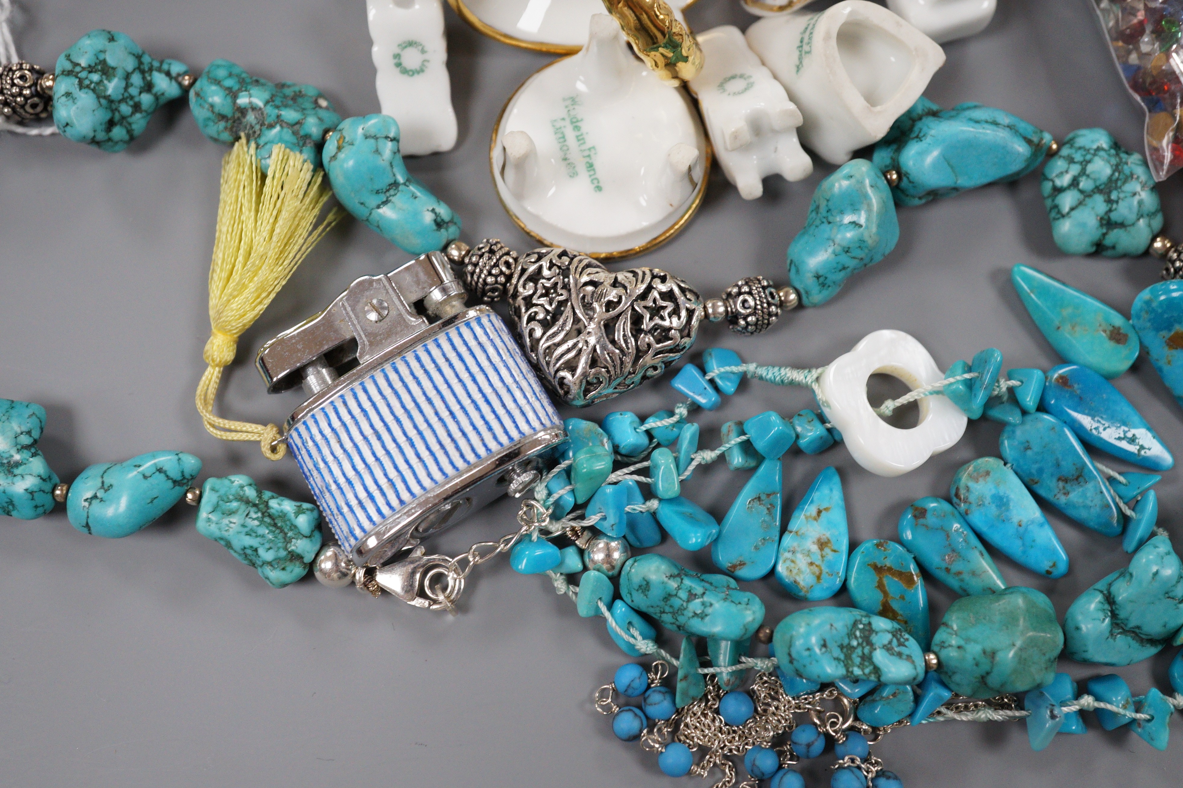 Nine miniature items of Limoges, including furniture, three turquoise necklaces, a group of assorted loose coloured paste stones and four assorted lighters.